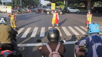 Angggota Komunitas Aku Badut Indonesia (ABI) melakukan aksi kampanye untuk menggunakan masker di kawasan Cilandak, Jakarta Selatan, Senin (12/7/2021). [Suara.com/Alfian Winanto]