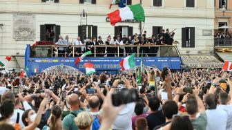 Para pemain Italia berada di atas bus saat perayaan juara Euro 2020 di Roma, Senin (12/7).  [AFP]
