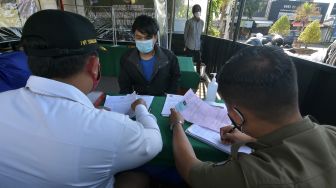 Petugas memberikan sanksi administrasi berupa denda Rp1 Juta kepada karyawan tempat usaha non esensial dalam sidang yustisi di Pos Sekat Uma Anyar, Denpasar, Bali, Selasa (13/7/2021). ANTARA FOTO/Nyoman Hendra Wibowo