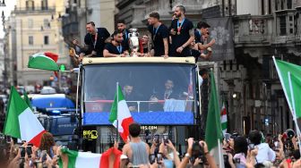 Para pemain Italia berada di atas bus saat perayaan juara Euro 2020 di Roma, Senin (12/7).  [AFP]
