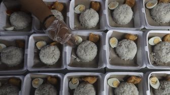 Sukarelawan menyiapkan makanan di dapur umum peduli COVID-19 di Karet Semanggi, Setiabudi, Jakarta, Selasa (13/7/2021). [Suara.com/Angga Budhiyanto]