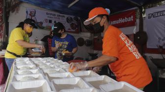 Sukarelawan menyiapkan makanan di dapur umum peduli COVID-19 di Karet Semanggi, Setiabudi, Jakarta, Selasa (13/7/2021). [Suara.com/Angga Budhiyanto]