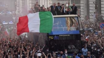 Para pemain Italia berada di atas bus saat perayaan juara Euro 2020 di Roma, Senin (12/7).  [AFP]