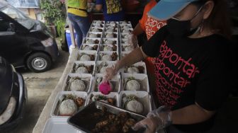 Sukarelawan menyiapkan makanan di dapur umum peduli COVID-19 di Karet Semanggi, Setiabudi, Jakarta, Selasa (13/7/2021). [Suara.com/Angga Budhiyanto]