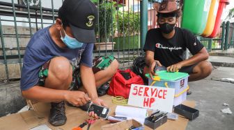 Penyedia jasa servis mereparasi handphone di  Kawasan Pusat Grosir Cililitan (PGC), Jakarta Timur, Selasa (13/7/2021). [Suara.com/Alfian Winanto]