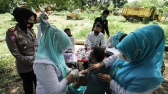 Petugas kesehatan menyuntikkan vaksin COVID-19 kepada warga pemulung di komplek Tempat Pembuangan Akhir (TPA) Alue Lim, Lhokseumawe, Aceh, Rabu (14/7/2021). ANTARA FOTO/Rahmad
