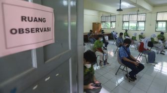 Para pelajar saat menjalani proses observasi usai menjalani vaksinasi Covid-19 di SMA Negeri 38, Jakarta Selatan, Kamis (15/7/2021). [Suara.com/Alfian Winanto]