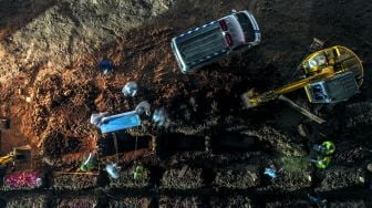 Foto udara warga berziarah di dekat pusara keluarganya di area pemakaman khusus COVID-19 di TPU Rorotan, Cilincing, Jakarta Utara, Kamis (15/7/2021).  ANTARA FOTO/M Risyal Hidayat