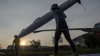 Atlet dayung PON DKI Jakarta memanggul perahu usai berlatih di arena dayung Jakabaring Sport CIty (JSC), Palembang, Sumatera Selatan, Kamis (15/7/2021). [ANTARA FOTO/Nova Wahyudi]