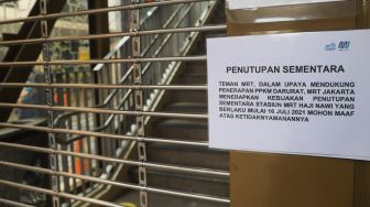 Kertas berisi pemberitahuan penutupan sementara stasiun dipajang di pintu masui Stasiun MRT Haji Nawi, Jakarta Selatan, Minggu (18/7/2021). [Suara.com/Alfian Winanto]