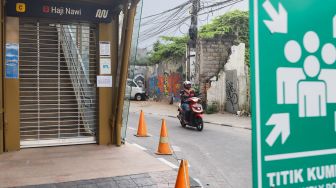 Warga melintas di Stasiun MRT Haji Nawi, Jakarta Selatan, Minggu (18/7/2021). [Suara.com/Alfian Winanto]