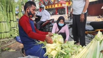 Warga memilih kulit ketupat di Pasar Palmerah, Jakarta Pusat, Minggu (18/7/2021). [Suara.com/Alfian Winanto]