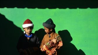 Dua anak jamaah An Nadzir bercengkerama usai melaksanakan Shalat Idul Adha di Kampung Butta Ejayya, Kecamatan Bontomarannu, Kabupaten Gowa, Sulawesi Selatan, Senin (19/7/2021). ANTARA FOTO/Abriawan Abhe
