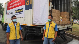 Petugas bersiap untuk membawa bantuan kemanusiaan bagi warga yang menjalani Isoman Covid-19 di Lapangan Monumen Nasional (Monas), Jakarta Pusat, Senin (19/7/2021). [Suara.com/Alfian Winanto]