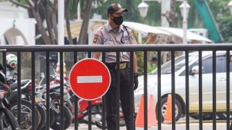 Petugas berjaga di pintu masuk Kantor Badan Pengawas Obat dan Makanan (BPOM), Jakarta Pusat, Senin (19/7/2021). [Suara.com/Alfian Winanto]