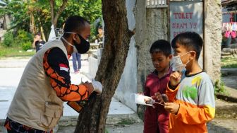 Relawan Satgas Covid-19 Bagi Ratusan Ribu Masker di 13 Daerah PPKM Darurat