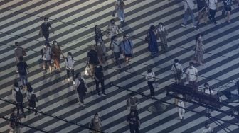 Sejumlah warga menyeberang jalan di kota Shinjuku, Tokyo, Jepang, Minggu (18/7/2021).  ANTARA FOTO/Sigid Kurniawan