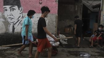 Warga membawa daging kurban yang akan dibagikan secara 'door to door' atau dari rumah ke rumah di kawasan Jati Padang Utara, Pasar Minggu, Jakarta, Selasa (20/7/2021). [Suara.com/Angga Budhiyanto]