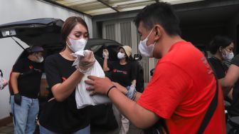 Lucinta Luna membagikan paket bantuan berupa daging kurban dan sembako kepada warga di sekitar rumah Pedangdut Dewi Perssik di Kawasan Fatmawati, Jakarta Selatan, Selasa (20/7/2021). [Suara.com/Alfian Winanto]