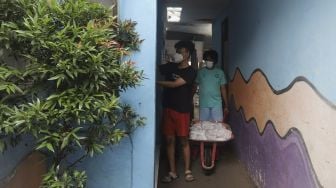 Warga membagikan daging kurban dari rumah ke rumah atau 'door to door' di kawasan Jati Padang Utara, Pasar Minggu, Jakarta, Selasa (20/7/2021). [Suara.com/Angga Budhiyanto]