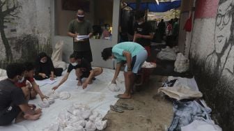 Warga bersiap membagikan daging kurban dari rumah ke rumah atau 'door to door' di kawasan Jati Padang Utara, Pasar Minggu, Jakarta, Selasa (20/7/2021). [Suara.com/Angga Budhiyanto]