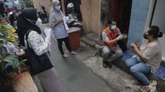 Petugas Pos menyalurkan Bantuan Sosial Tunai (BST) dari rumah ke rumah di kawasan Petojo Selatan, Gambir, Jakarta, Rabu (21/7/2021). [Suara.com/Angga Budhiyanto]