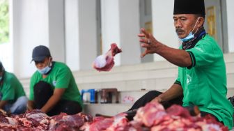 Petugas memotong daging hewan kurban di Masjid Agung Al Azhar, Jakarta Selatan, Rabu (21/7/2021). [Suara.com/Alfian Winanto]