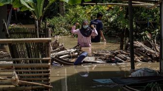 Warga mengevakuasi barang-barang yang terendam banjir di Desa Jeruklegi Wetan, Jeruklegi, Cilacap, Jawa Tengah, Rabu (21/7/2021). ANTARA FOTO/Idhad Zakaria