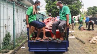 Petugas membawa daging dan bagian dari hewan kurban yang sudah disembelih untuk selanjutnya diolah di Masjid Agung Al Azhar, Jakarta Selatan, Rabu (21/7/2021). [Suara.com/Alfian Winanto]