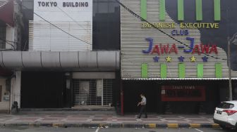 Warga berjalan di depan pertokoan yang tutup di kawasan Melawai, Jakarta, Rabu (21/7/2021). [Suara.com/Angga Budhiyanto]