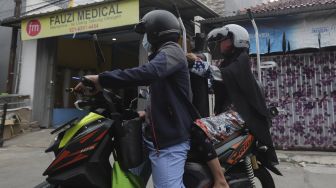 Warga membawa tabung oksigen medis usai diisi ulang di toko alat kesehatan Fauzi Medical, Matraman, Jakarta, Kamis (22/7/2021). [Suara.com/Angga Budhiyanto]