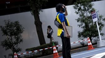 Petugas menunggu tibanya bus yang akan membawa peserta Olimpiade Tokyo 2020 di Tokyo International Forum, Tokyo, Jepang, Rabu (21/7/2021).  ANTARA FOTO/Sigid Kurniawan