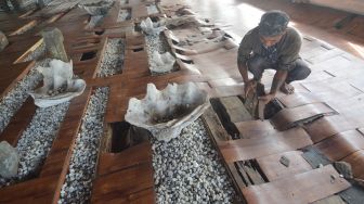 Warga membersihkan lantai rusak di Komplek Makam Syekh Burhanuddin, Ulakan, Padangpariaman, Sumatera Barat, Kamis (22/7/2021). ANTARA FOTO/Iggoy el Fitra