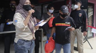 Warga mendapatkan paket sembako usai menjalani vaksin COVID-19 di Rusun Petamburan, Tanah Abang, Jakarta, Kamis (22/7/2021). [Suara.com/Angga Budhiyanto]