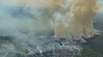 Pesawat tempur F-16 dari Skadron Udara 16/Rydder Lanud Roesmin Pekanbaru, terbang diatas lahan yang terbakar di Koto Tuo, Kampar, Riau, Rabu (21/7/2021).  [ANTARA FOTO]