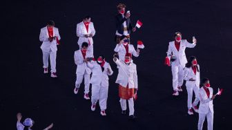 Kontingen Indonesia mengikuti defile dalam pembukaan Olimpiade Tokyo 2020 di Stadion Nasional, Tokyo, Jepang, Jumat (23/7/2021). [ANTARA FOTO/Sigid Kurniawan]