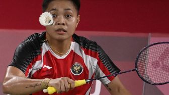 Atlet Indonesia Apriyani Rahayu melakukan pukulan dalam pertandingan penyisihan grup bulu tangkis ganda putri melawan Lee Meng Yean dan Chow Mei Kuan dari Malaysia selama Olimpiade Tokyo 2020 di Musashino Forest Sports Plaza, Tokyo, Sabtu (24/7/2021). [Alexander NEMENOV / AFP]