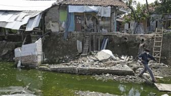 Warga melihat kondisi rumah yang rusak akibat longsor di Desa Kertasmaya, Indramayu, Jawa Barat, Sabtu (24/7/2021). [ANTARA FOTO/Dedhez Anggara]