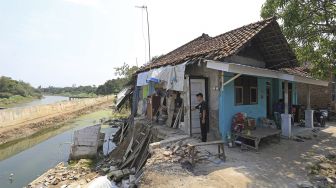 Warga melihat kondisi rumah yang rusak akibat longsor di Desa Kertasmaya, Indramayu, Jawa Barat, Sabtu (24/7/2021). [ANTARA FOTO/Dedhez Anggara]