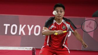 Atlet Indonesia Apriyani Rahayu melakukan pukulan dalam pertandingan penyisihan grup bulu tangkis ganda putri melawan Lee Meng Yean dan Chow Mei Kuan dari Malaysia selama Olimpiade Tokyo 2020 di Musashino Forest Sports Plaza, Tokyo, Sabtu (24/7/2021). [Alexander NEMENOV / AFP]