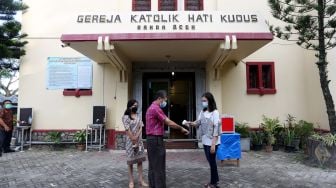 Petugas melakukan pengecekan suhu tubuh, pemakaian masker, dan mencuci tangan sebagai bagian pelaksanaan protokol kesehatan (prokes) COVID-19 sebelum melaksanakan ibadah di gereja Hati Kudus, Banda Aceh, Aceh, Minggu (25/7/2021). ANTARA FOTO / Irwansyah Putra