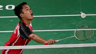 Pebulutangkis tunggal putra Indonesia Anthony Ginting mengembalikan shuttlecock ke arah lawannya pebulutangkis tunggal putra Hongaria Gergely Krausz dalam laga Tunggal Putra Grroup J Olimpiade Tokyo 2020, di Musashino Forest Sport Plaza, Tokyo,, Jepang, Minggu (25/7/2021). [AFP]