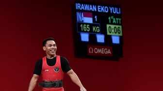 Lifter Indonesia Eko Yuli Irawan tersenyum seusai melakukan angkatan clean and jerk dalam kelas 61 kg Putra Grup A Olimpiade Tokyo 2020 di Tokyo International Forum, Tokyo, Jepang, Minggu (25/7/2021). ANTARA FOTO/Sigid Kurniawan