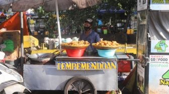 Pedagang kaki lima menunggu pembeli di sekitar kawasan Sudirman, Jakarta Pusat, Senin (26/7/2021). [Suara.com/Alfian Winanto]