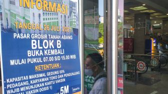 Poster berisi informasi mengenai syarat bagi warga untuk bisa masuk dan berbelanja di Blok B Pasar Tanah Abang, Jakarta Pusat, Senin (26/7/2021). [Suara.com/Alfian Winanto]