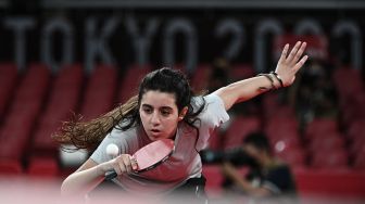 Petenis meja Suriah Hend Zaza mengembalikan pukulan Liu Jia dari Austria selama pertandingan babak penyisihan tunggal tenis meja putri di Olimpiade 2020, Tokyo, Jepang, Sabtu (24/7). [AFP]