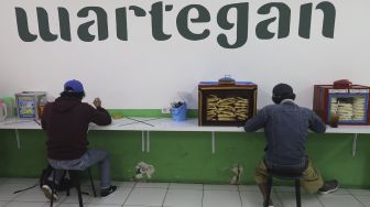 Pembeli menyantap hidangan makanan di Wartegan, Ampera, Jakarta, Senin (26/7/2021). [Suara.com/Angga Budhiyanto]