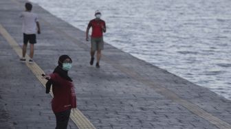 Warga berolahraga di kawasan Danau Sunter, Jakarta, Selasa (27/7/2021). [Suara.com/Angga Budhiyanto]