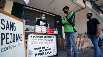 Seorang pemilik kedai kopi memberikan makan siang gratis kepada pengemudi ojek daring di Gading Serpong, Tangerang, Banten, Selasa (27/7/2021). ANTARA FOTO/Muhammad Iqbal