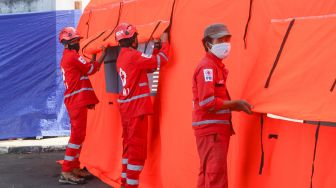 Petugas memeriksa kesiapan tenda atau selter untuk isolasi mandiri bagi masyarakat di Jl. Gatot Subroto Kav 97 RW 4, Mampang Prapatan, Jakarta Selatan, Selasa (27/7/2021). [Suara.com/Alfian Winanto]